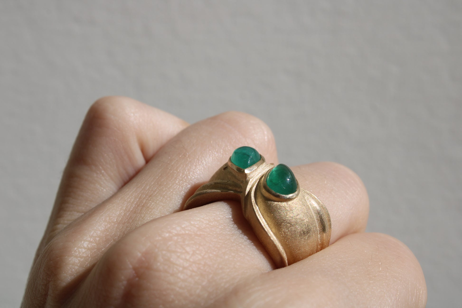 Toi et moi rings: the most romantic of rings. Symbolizing two parts of a whole, or symbolizing the interconnected nature of our internal tensions. I think there's something scared about this type of interlocking geometry and there's an infinite world of glamour inside of this specific form.&nbsp;  Natural Colombian emeralds nestled in nearly raw recycled 10k gold are pictured. 